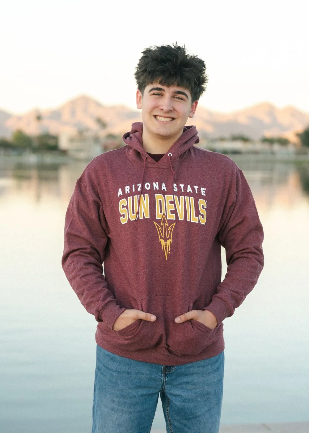Senior portrait in an Arizona State hoodie by the lake